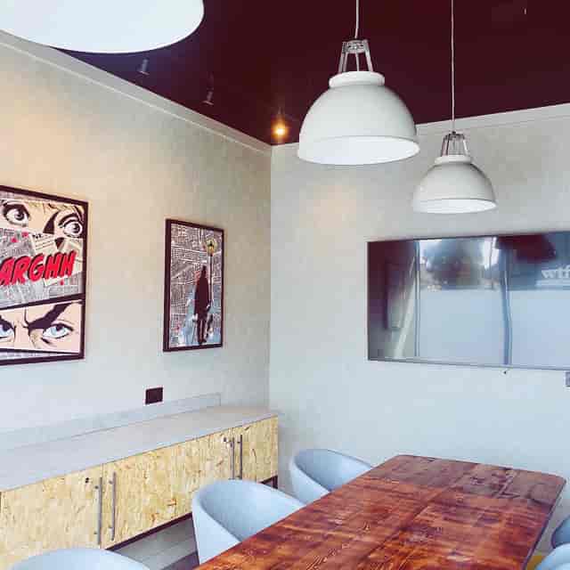 Modern meeting space at Holiday Inn Whitechapel with wooden table and vibrant artwork.