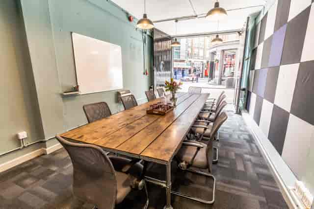 Modern meeting room with wooden table, ideal for collaboration and brainstorming events.