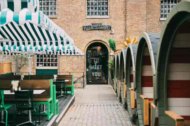 Outdoor venue at The Pizza Playground with striped awnings for casual events and meetings.