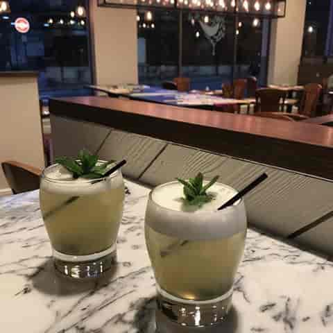 Elegant cocktails on marble table at Assenheims Bar & Grill for networking events.
