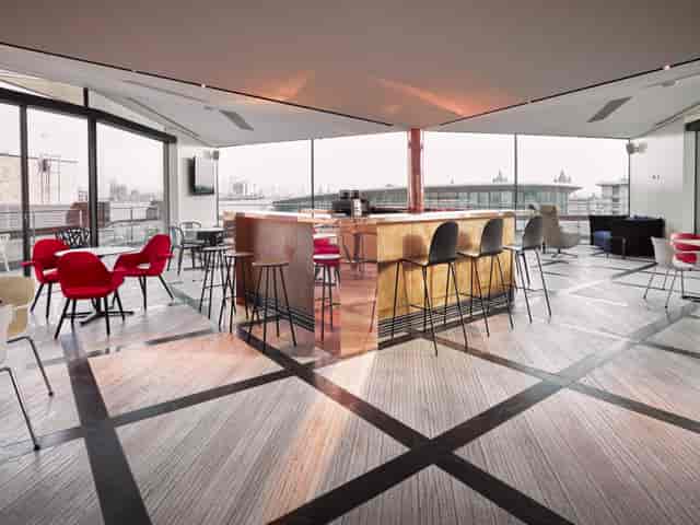 Modern penthouse breakout space with copper bar for evening receptions and corporate networking.