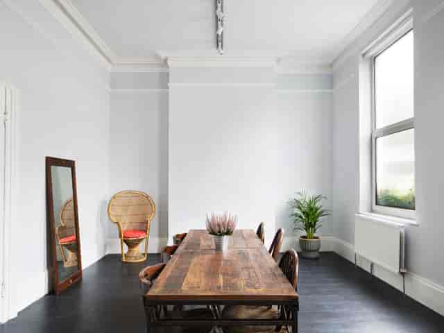 Minimalist meeting space with wooden table, natural light, ideal for brainstorming sessions.
