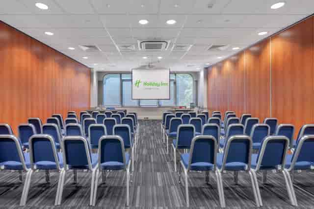 Meeting room at Holiday Inn Kensington with blue chairs for corporate events.
