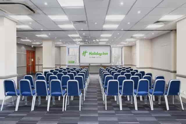 Meeting space with blue chairs at Holiday Inn Kensington for conferences and workshops.