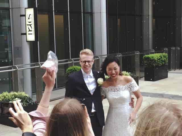 Joyful couple celebrating wedding in modern urban venue with engaged guests.