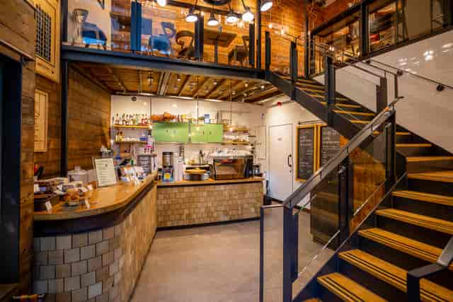 Stylish multi-level event venue with modern barista counter and warm decor.