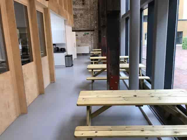 Modern Exhibition Hall with wooden tables, ideal for networking events and meetings.