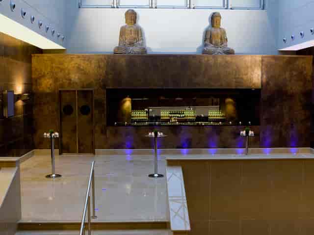 Atrium at The May Fair Hotel, sleek bar and Buddha statues for cocktail receptions.