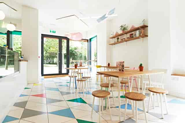 Bright gelato cafe with colorful tiled floor, perfect for casual meetings and gatherings.