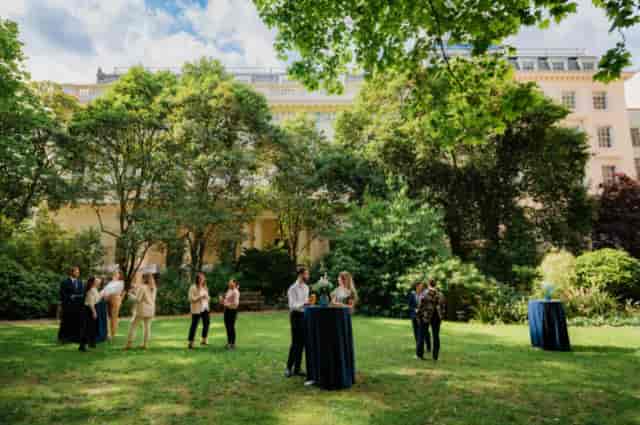 Outdoor networking event in Carlton Room, 116 Pall Mall, with high-top tables and lush garden.