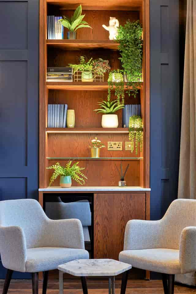 Stylish meeting space at The Shaftesbury, featuring wooden shelves and greenery for events.