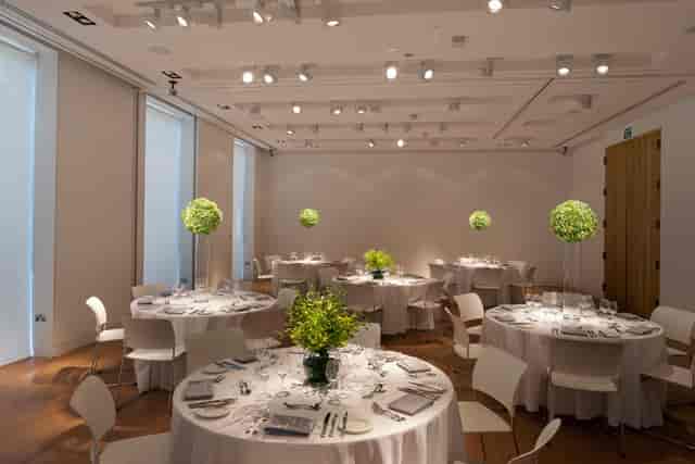 Elegant dinner setup in The Goldsmiths' Centre with round tables and lush centerpieces.