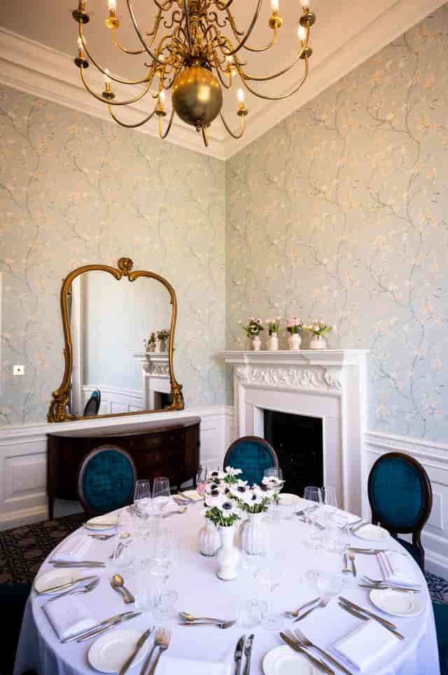 Elegant meeting space with vintage mirror and fireplace for intimate events.