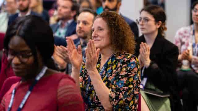 Engaged audience applauding at Port of Liverpool Suite conference event.