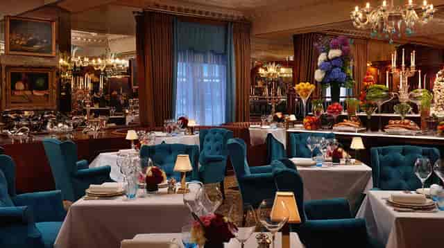 Elegant dining at The English Grill with plush turquoise seating for upscale events.