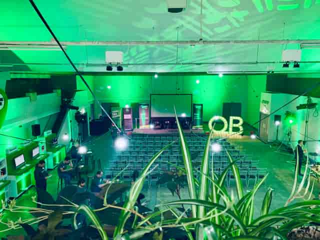 Event Hall in Hinterlands with green lighting set for a conference presentation.