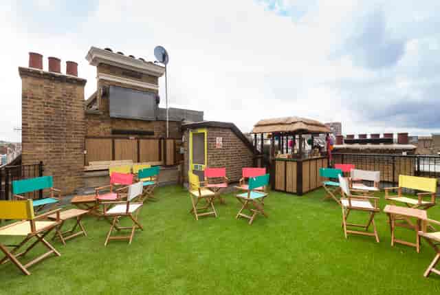 Vibrant rooftop event space with colorful chairs for summer parties and casual networking.