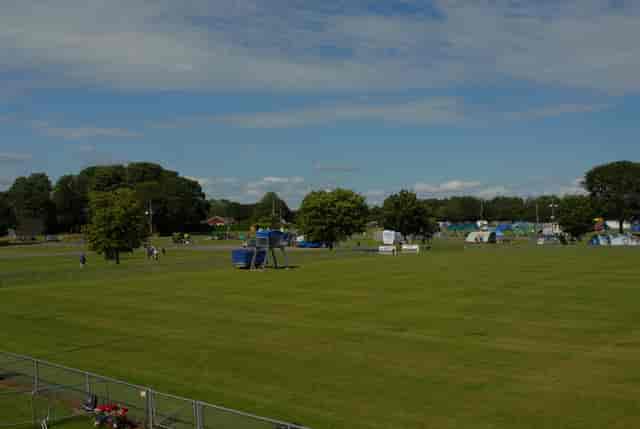 Spacious outdoor venue in South England, perfect for events with natural shade and clear skies.