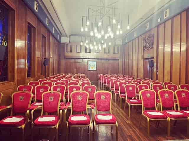 Elegant red chairs in The Livery Hall, perfect for formal events and conferences.