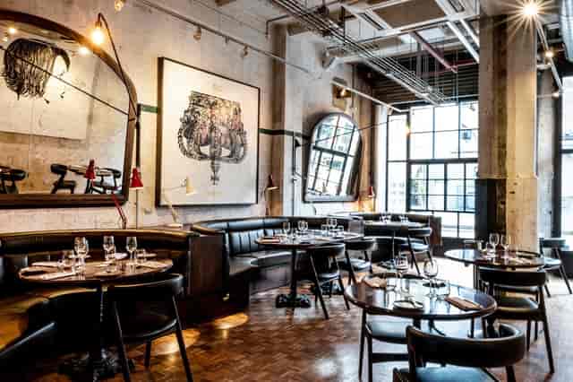 Stylish restaurant venue with round tables for corporate events and private dinners.