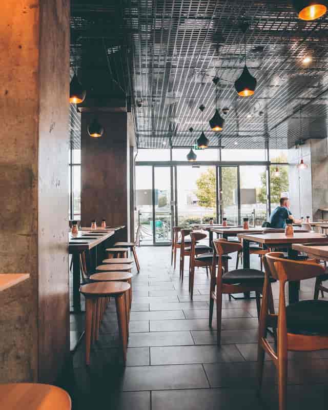 Modern restaurant venue with large windows, perfect for casual meetings and small events.