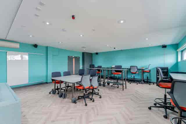 Modern meeting space in FACT Liverpool with teal walls, ideal for workshops and brainstorming.
