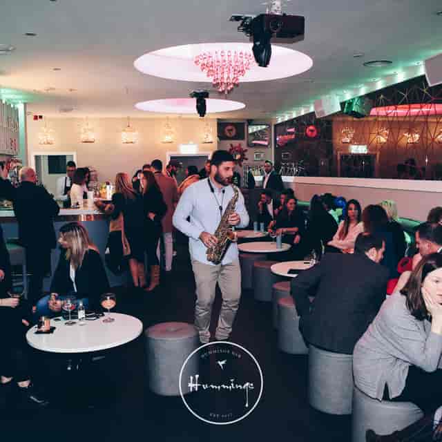 Vibrant event space with saxophonist, perfect for networking and social gatherings.