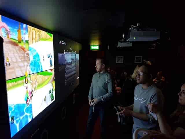 Dynamic gaming event setup with large screen for corporate team-building and networking.