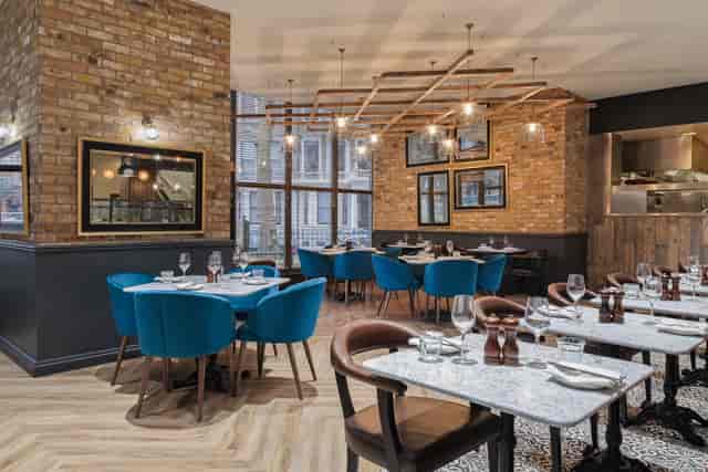 Modern restaurant in Holiday Inn Kensington, featuring stylish blue chairs for events.