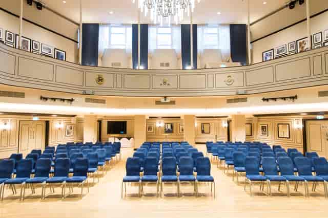 Carisbrooke Hall conference setup with blue chairs and elegant decor for engaging events.