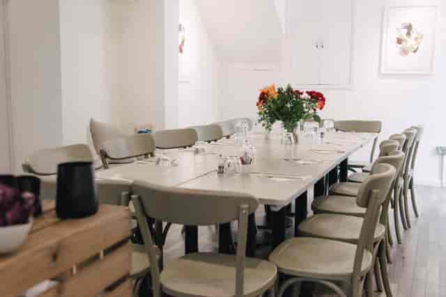 Intimate meeting space with long table, ideal for workshops and corporate events.