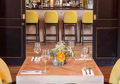 Stylish restaurant with warm wooden table, perfect for intimate meetings and events.
