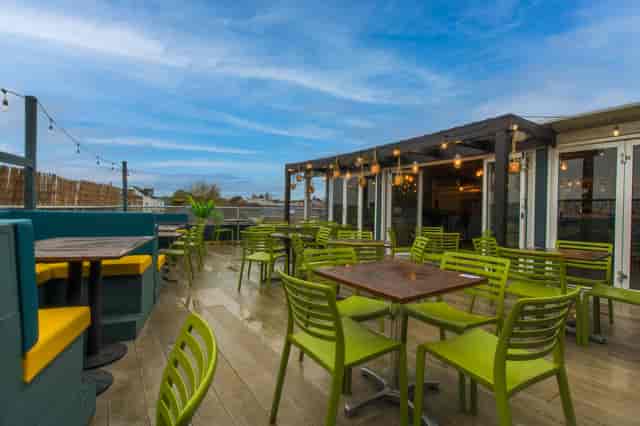 Vibrant rooftop venue with green chairs for casual meetings and events in Southampton.