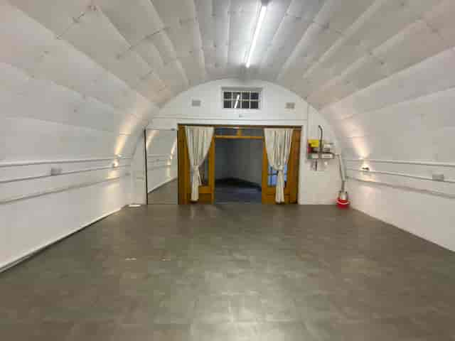 Versatile event space with arched ceiling for workshops and seminars at Sunshine International Arts.