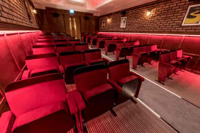 Stylish intimate event space with plush seating for presentations and screenings.