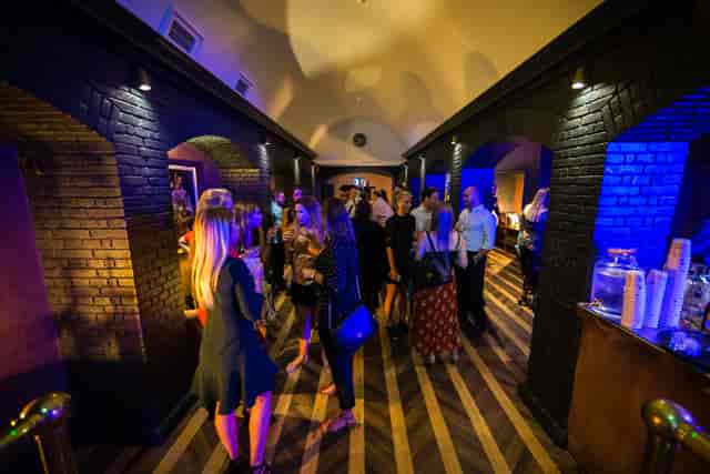 Stylish event space with high ceilings and ambient blue lighting for networking events.