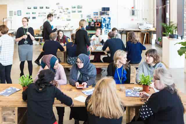 Vibrant networking event on Mezanine Floor at R.A.W Labs with communal tables and greenery.