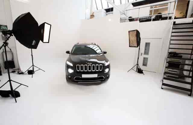 Sleek vehicle in minimalist studio for automotive product launch event.