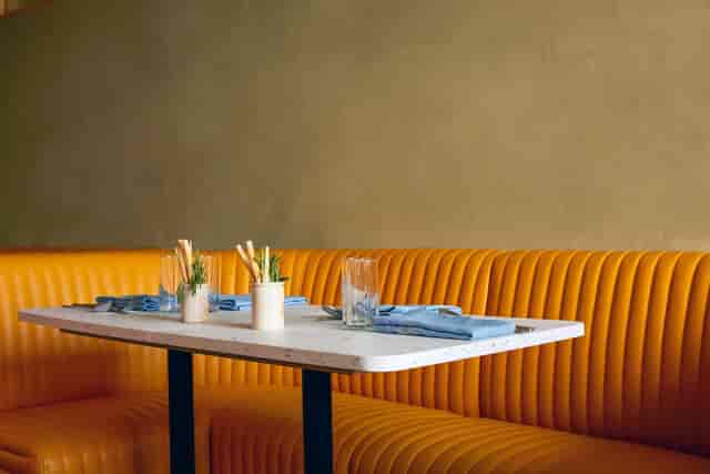 Stylish restaurant dining setup with marble table and orange seating for networking events.