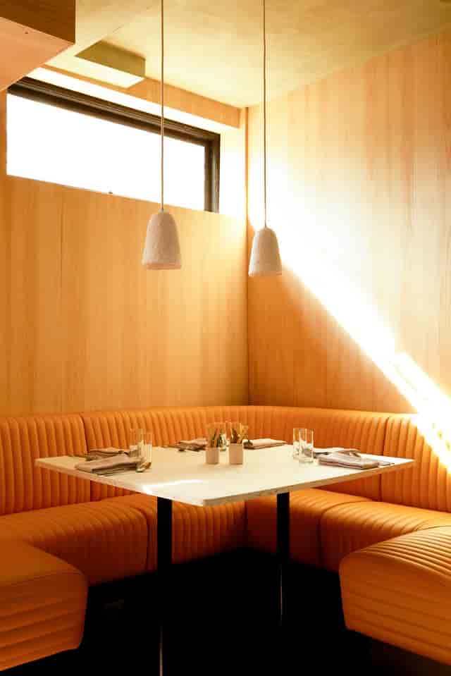 Modern restaurant interior with warm wood tones, ideal for intimate meetings and small events.