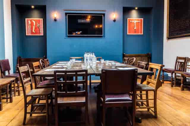 Intimate meeting space with wooden tables, ideal for gatherings and presentations.