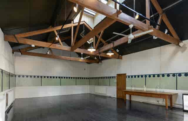 Spacious event space with high ceilings in The Stables, Park Village for meetings and workshops.
