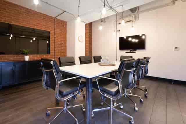 Modern conference room with sleek table, smart tech; ideal for meetings and collaborations.