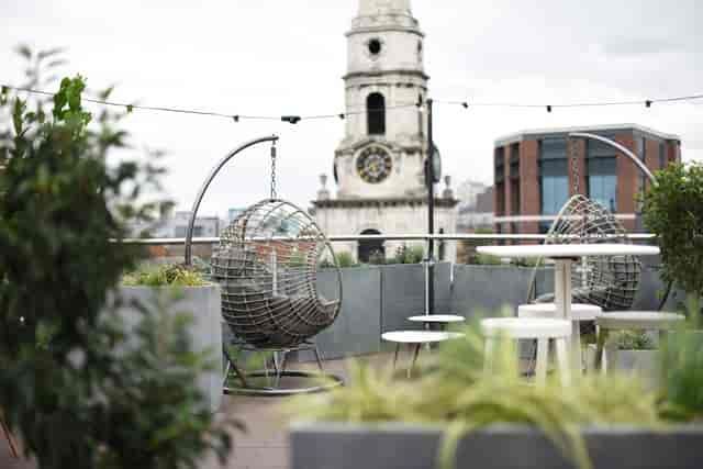 Stylish rooftop terrace with swing chairs and skyline views for networking events in Uncommon Borough.