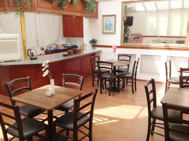 Cozy meeting room with wooden tables, ideal for small gatherings and breakout sessions.