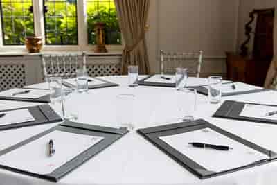 Boardroom Suite at Greenwoods Hotel, round table setup for meetings with natural light.