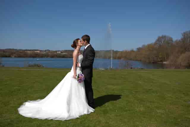 Outdoor wedding at Riverside 4, Crowne Plaza Marlow, with lake backdrop and lush lawn.