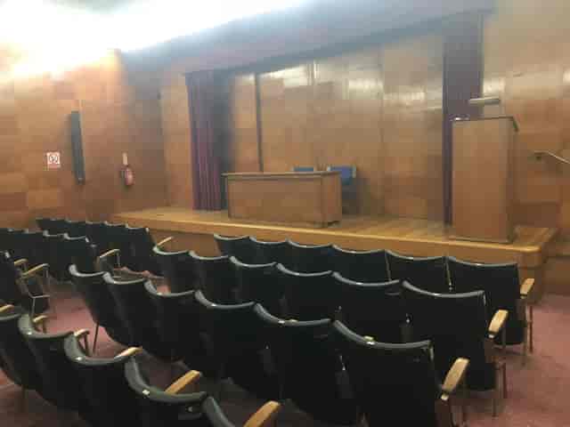 Auditorium with wood-paneled walls, ideal for theater-style meetings and corporate event venue hire.