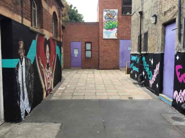 Vibrant alleyway with colorful murals for outdoor events and creative workshops.