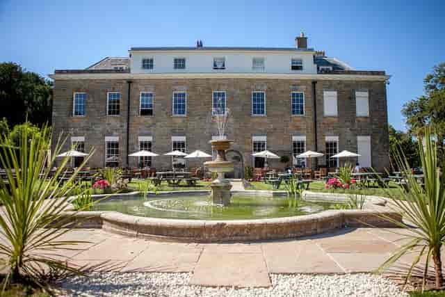 Elegant outdoor venue at Proud Country House with charming fountain for weddings and events.